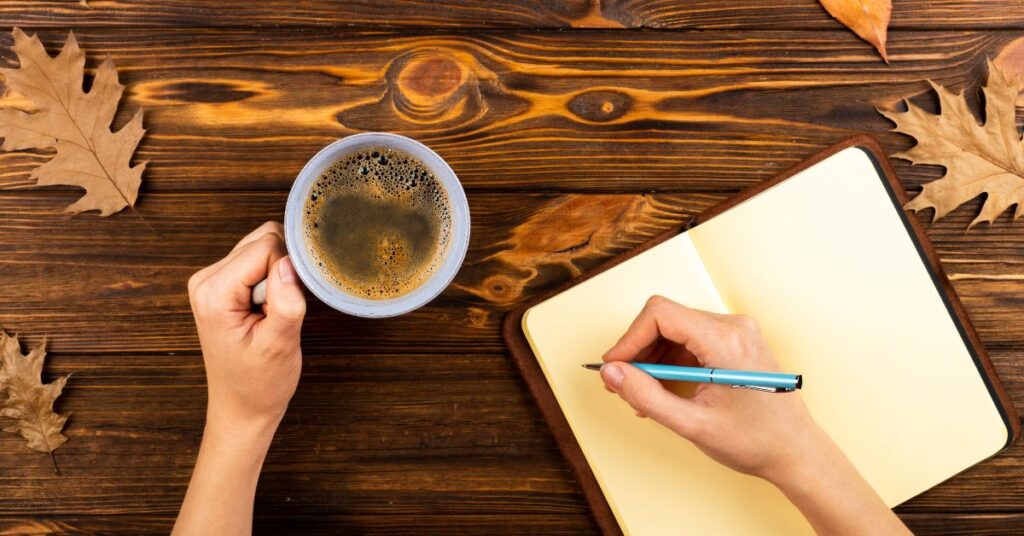 A hand writing in a gratitude journal or a peaceful desk setup.