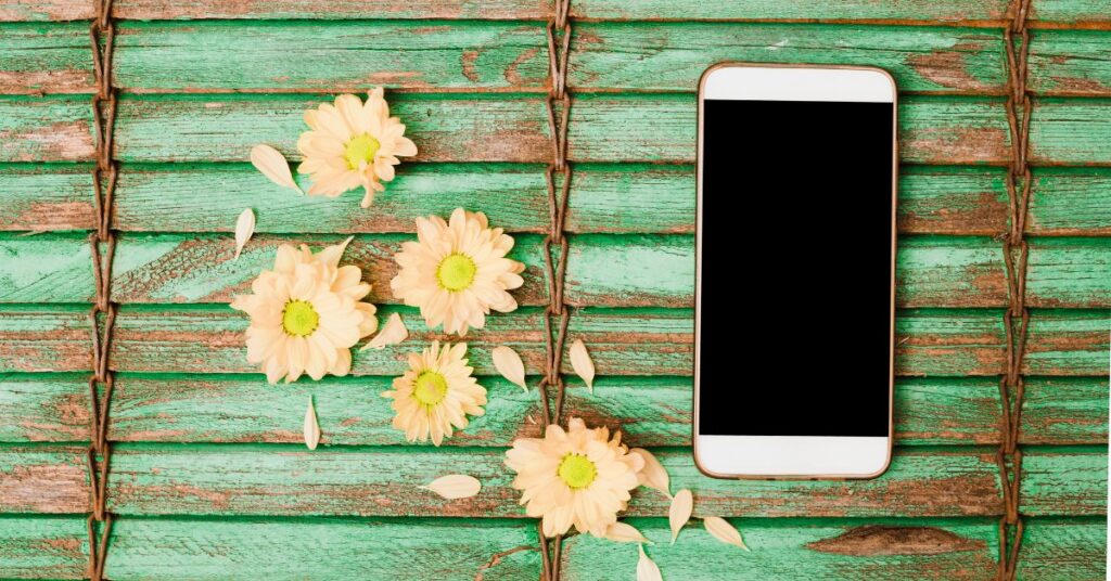 A phone turned upside down next to a book or nature setting.